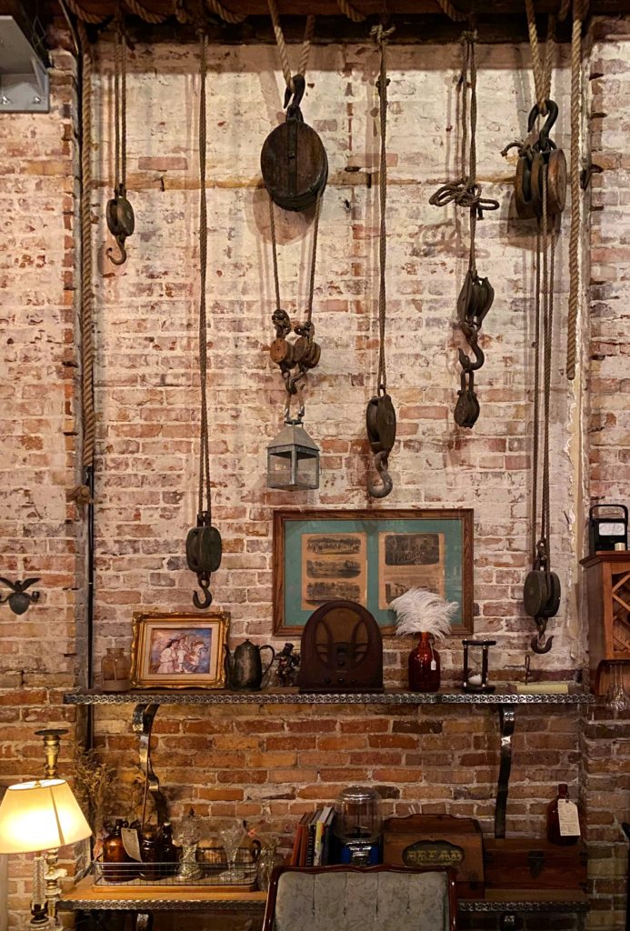 Speakeasy design style - Mathers, Orlando. Hanging hooks and artifacts as artwork against brick wall.