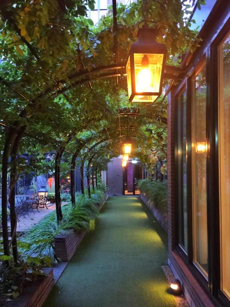 Whimsical arched corridor leading to the garden at the Andaz hotel in Amsterdam.