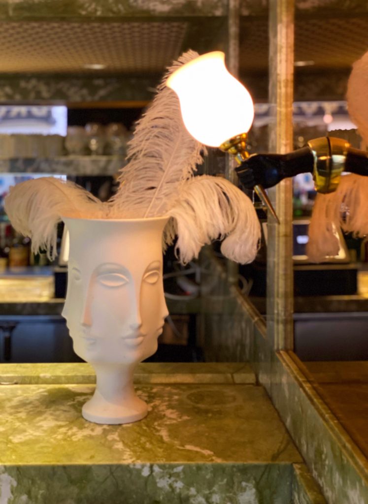 Quirky Boho decor with a multi-face vase and white feathers at Mini Bar at the Parker Palm Springs Hotel.