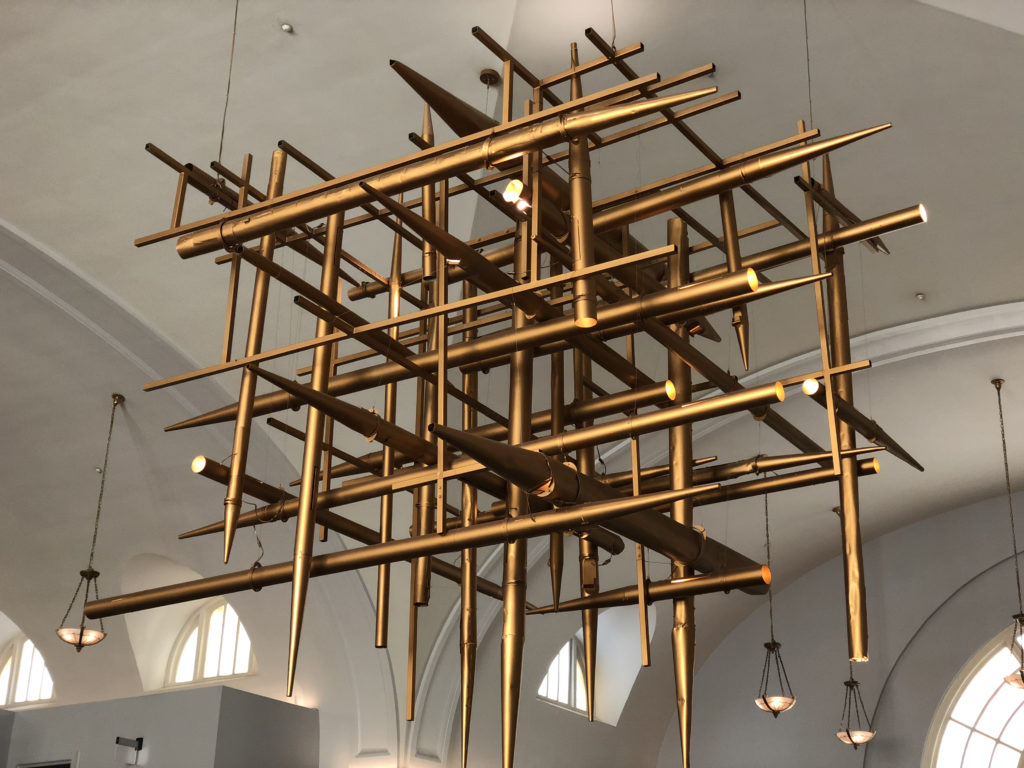 Eclectic interior design atrium with pipe organ transformed into feature atrium chandelier in matte brass at the Line Hotel in Washington DC.