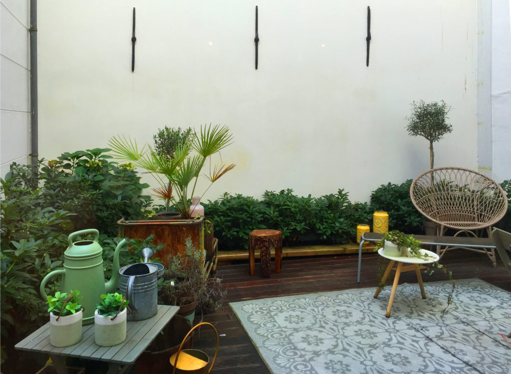 Hidden rooftop garden terrace with colorful plants and Boho furniture.