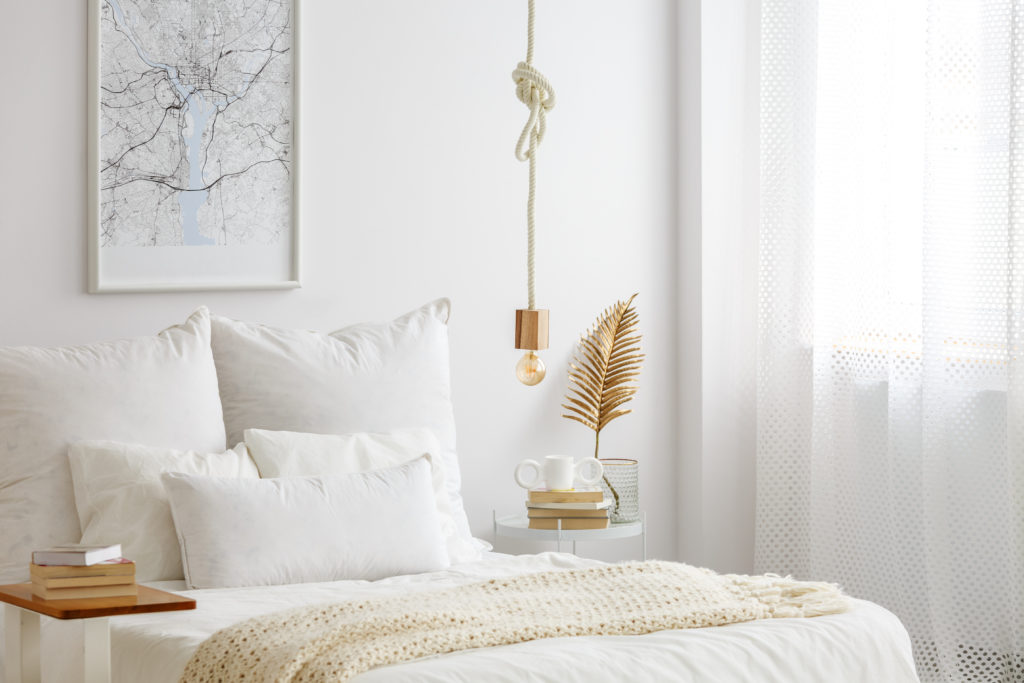 White bedroom, interior design with hanging rope lamp and neutral bedding and draperies.White bedroom, interior design with hanging rope lamp and neutral bedding and draperies.