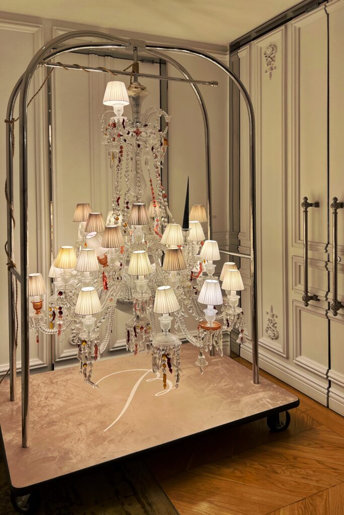 An iconic glass chandelier hangs off a bell cart in the Baccarat Hotel in New York City.