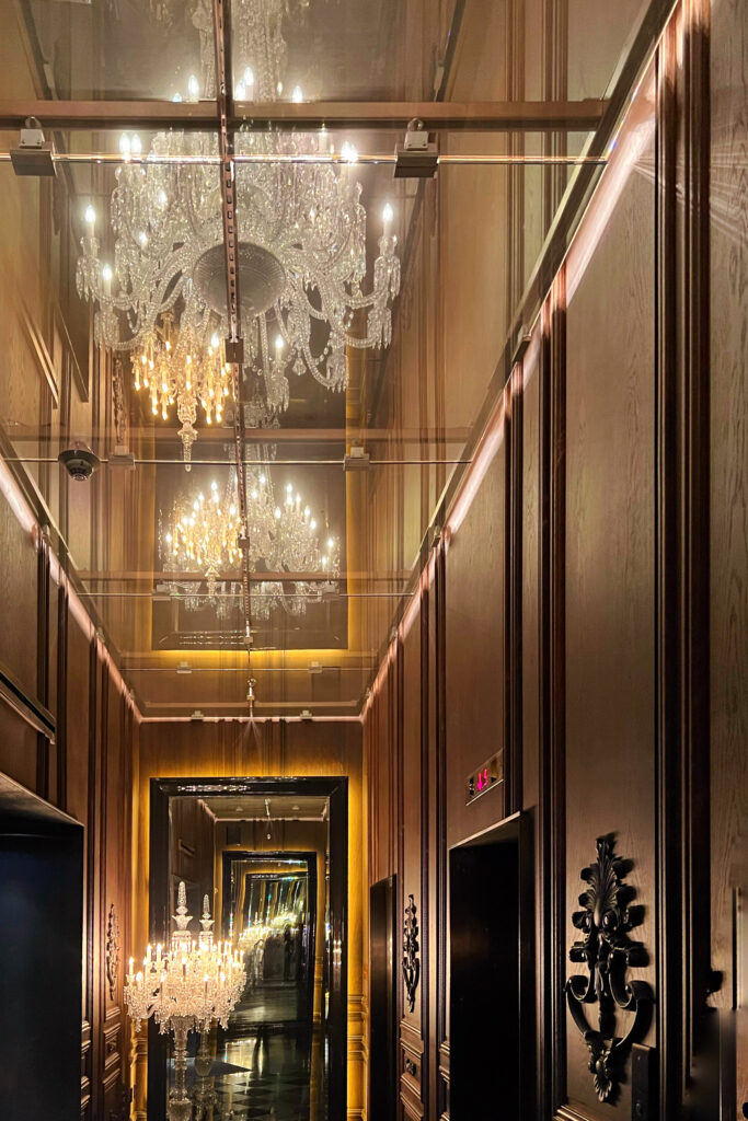 Aesthetic Travel Guide to New York City - Baccarat Hotel entry with glittering chandeliers overhead.