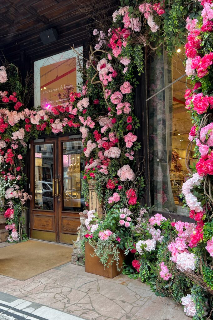 Aesthetic Travel Guide to New York City - ABC Carpet & Home, main entry with pink floral garland at doorway.