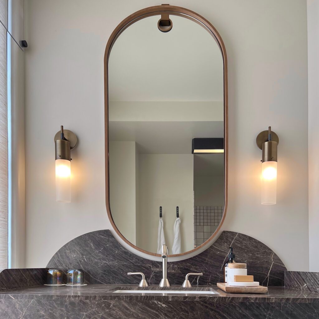 Luxury hotel in dowtown Los Angeles - Curved bathroom vanity and oval mirror in the guest room at the Proper Hotel.