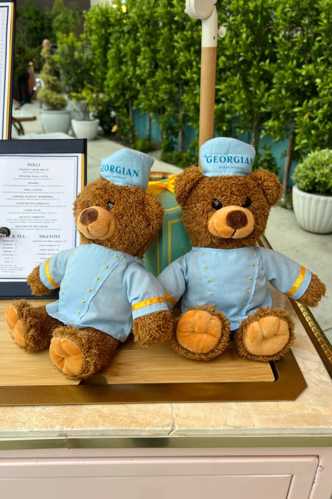Two bellhop teddy bears wearing the Georgian Hotel uniform at the entrance to the hotel.