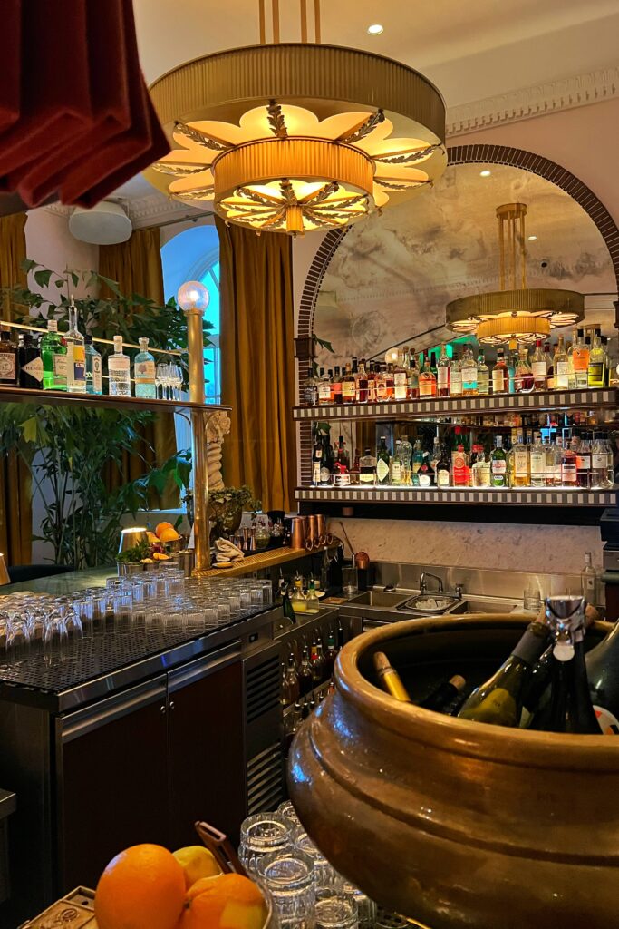 Sunset Bar in the lobby of the Georgian Hotel in Santa Monica with Art Deco style chandelier and smoked mirror liquor display.