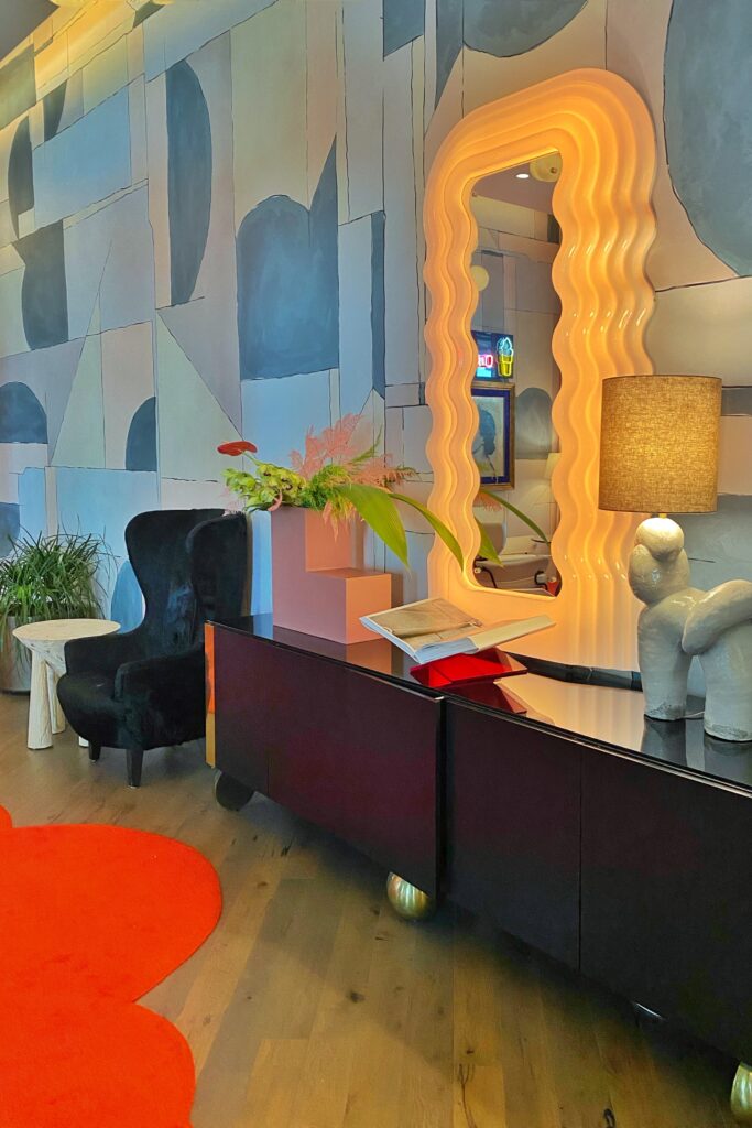 Wavy mirror and bold artwork in the Dopamine Decor interior design trend at the Virgin Hotel in Dallas, Texas.