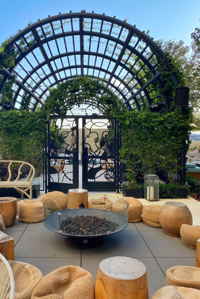 Whimsical artwork and arched garden entry in the fire pit at the rooftop of the Virgin Hotel in Dallas, Texas.
