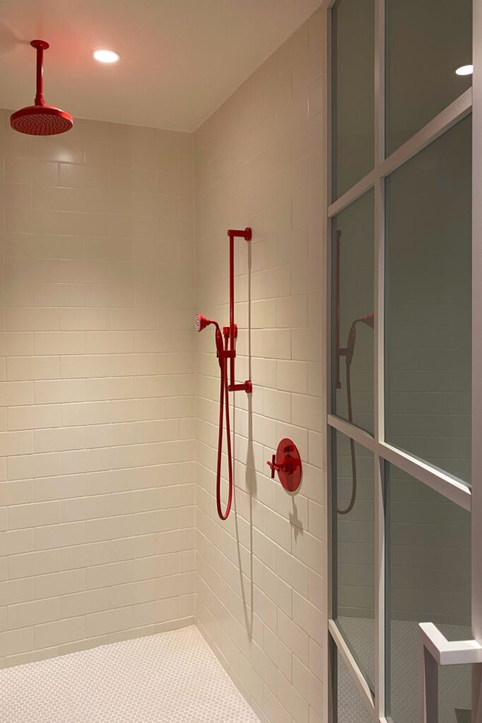 Dopamine decor details in the bright red shower and plumbing fixtures at the Virgin Hotel in Dallas, Texas.
