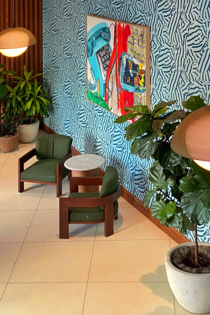Potted plants, bold artwork, and wild wallpaper in the Dopamine Decor interior design style at the Virgin Hotel in Dallas, Texas.
