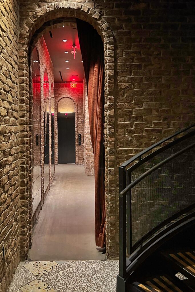 Arched brick doorway down the corridor inside the Civilian Hotel, one of New York City's most aesthetic spaces.