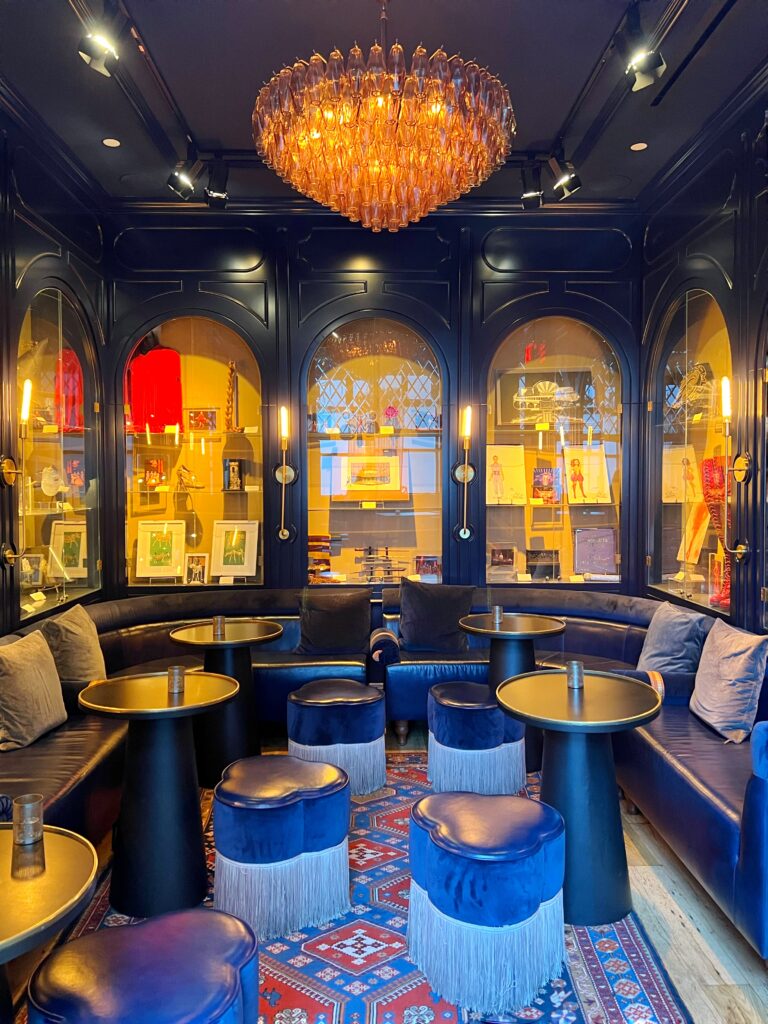 Blue Room with arched shelves holding Broadway memorabilia, inside the Civilian Hotel, one of New York City's most aesthetic spaces.