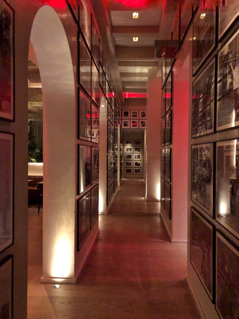 View looking down corridor with art gallery walls inside the Edition Hotel in Times Square, New York City. Shelf styling inspired by luxury hotels.