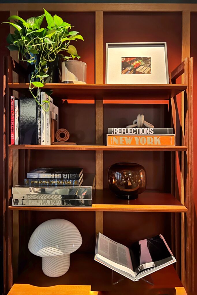 Bookshelf with styled accessories inside the Romer Hells Kitchen Hotel, one of New York City's most aesthetic spaces.