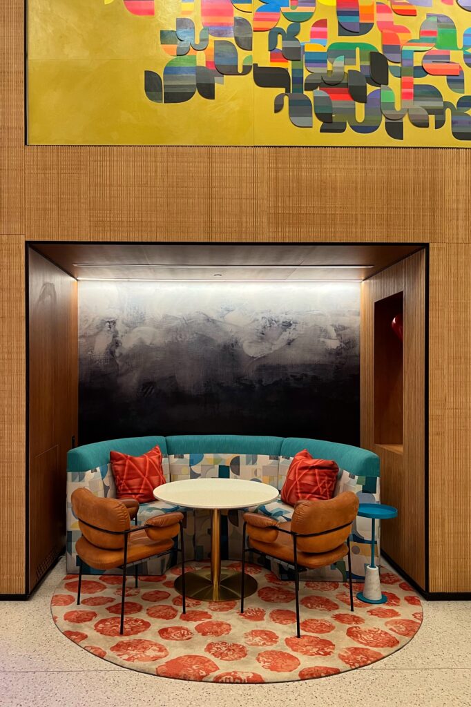 Colorful lounge seating in niche under modern artwork inside the lobby of the Wave Hotel in Orlando, Florida. Shelf styling inspired by luxury hotels.