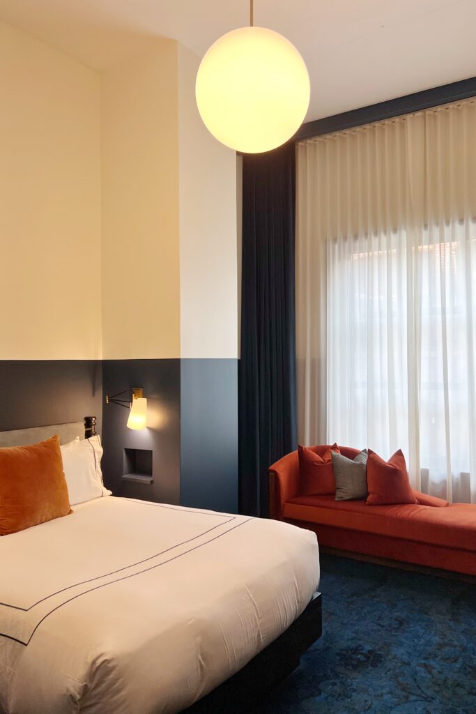Dream Hotel Nashville guestroom with bold color blocking, velvet chaise, and modern lighting — a stylish pick for the Nashville Aesthetic Travel Guide.