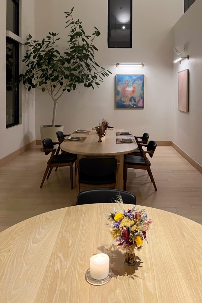 Minimalist dining room at June restaurant in Nashville with Scandinavian-style furniture, modern artwork, and soft candlelight.