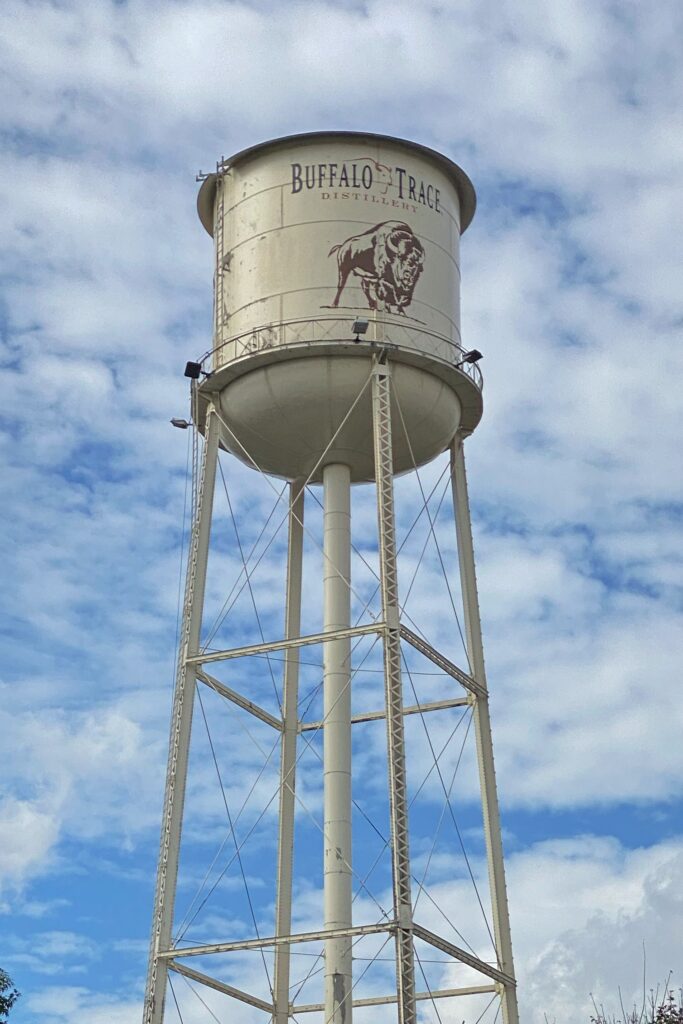 Close-up of the Buffalo Trace Distillery water tower with the bison logo in Frankfort, Kentucky, set against a blue sky—an iconic landmark on the Kentucky Bourbon Trail.