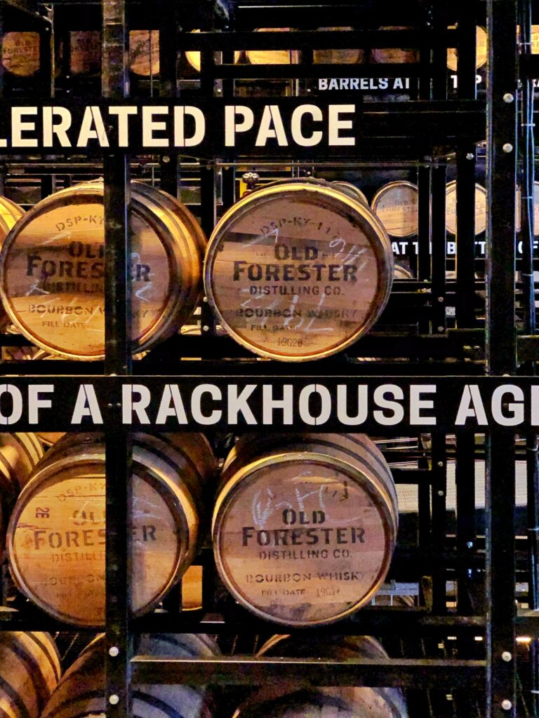 Close-up of Old Forester bourbon barrels stacked in a black steel rackhouse display at Old Forester Distilling Co. in Louisville, Kentucky.